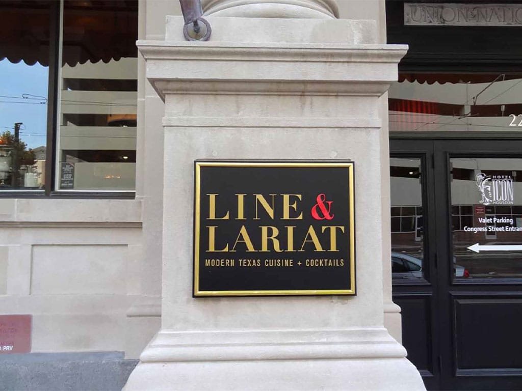 Line and Lariat plaque mounted on a stone pillar at the entrance