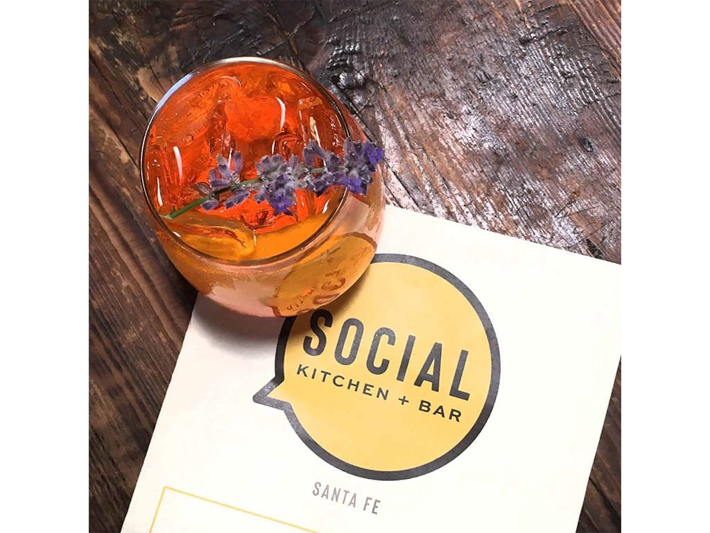 Cocktail with flowers resting on a Social menu